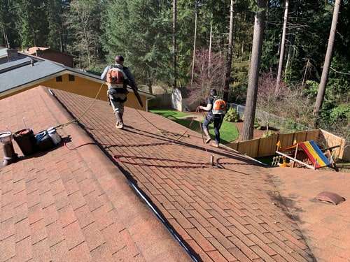 Rainier workers cleaning roof